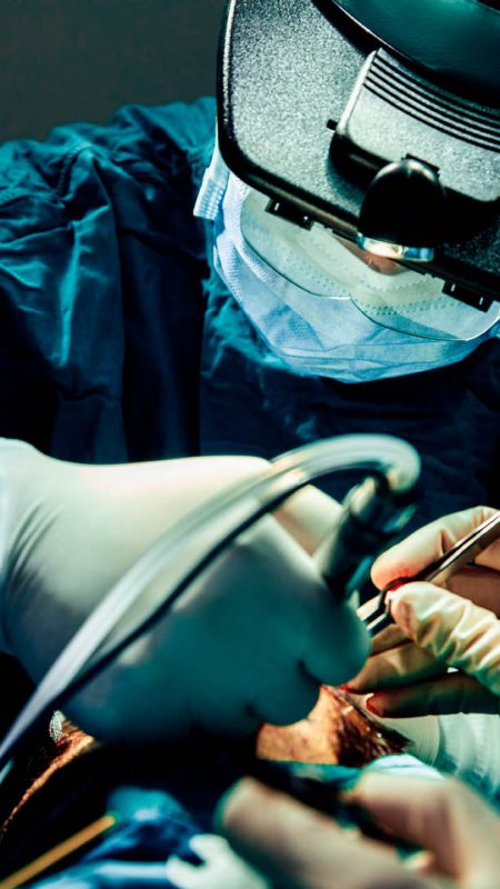 Close up doctor with surgical tools making surgery in the operating room, baldness treatment, hair transplant